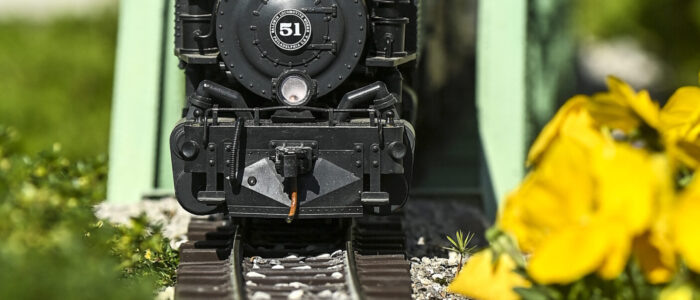 A train rides on a steel through truss in Barb and Mark Brown’s garden railroad.