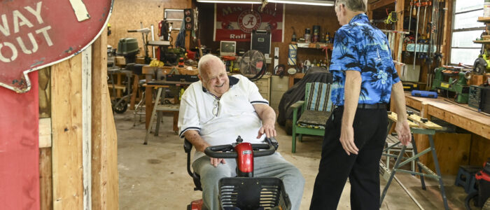 Senior Companion program volunteer Raymond Ruth, right, and Samuel Jones share a laugh in Jones’ shed, where they spend most of the time together.