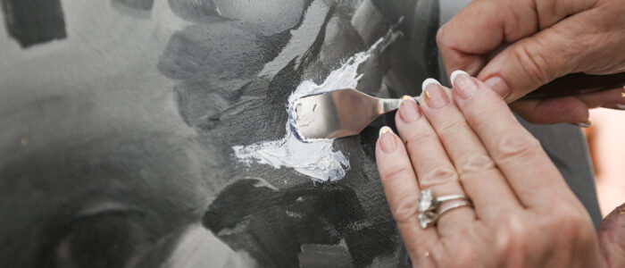 Char Baxter uses a painting knife as she woks on a new project.