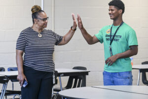 Shannon Shackelford high-fives Ta’Veon Goldsmith