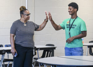 Shannon Shackelford high-fives Ta’Veon Goldsmith