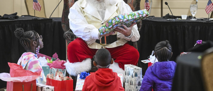 Paul Martin/Santa Claus gives presents to children during the Kiwanis Club’s Christmas lunch. [JERONIMO NISA]